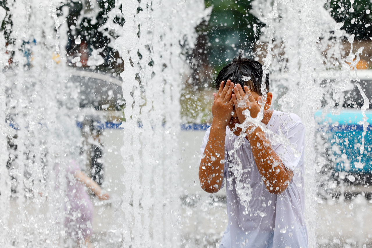 A child plays in the water in Gwanghwamun Square in central Seoul on Friday. (Yonhap)