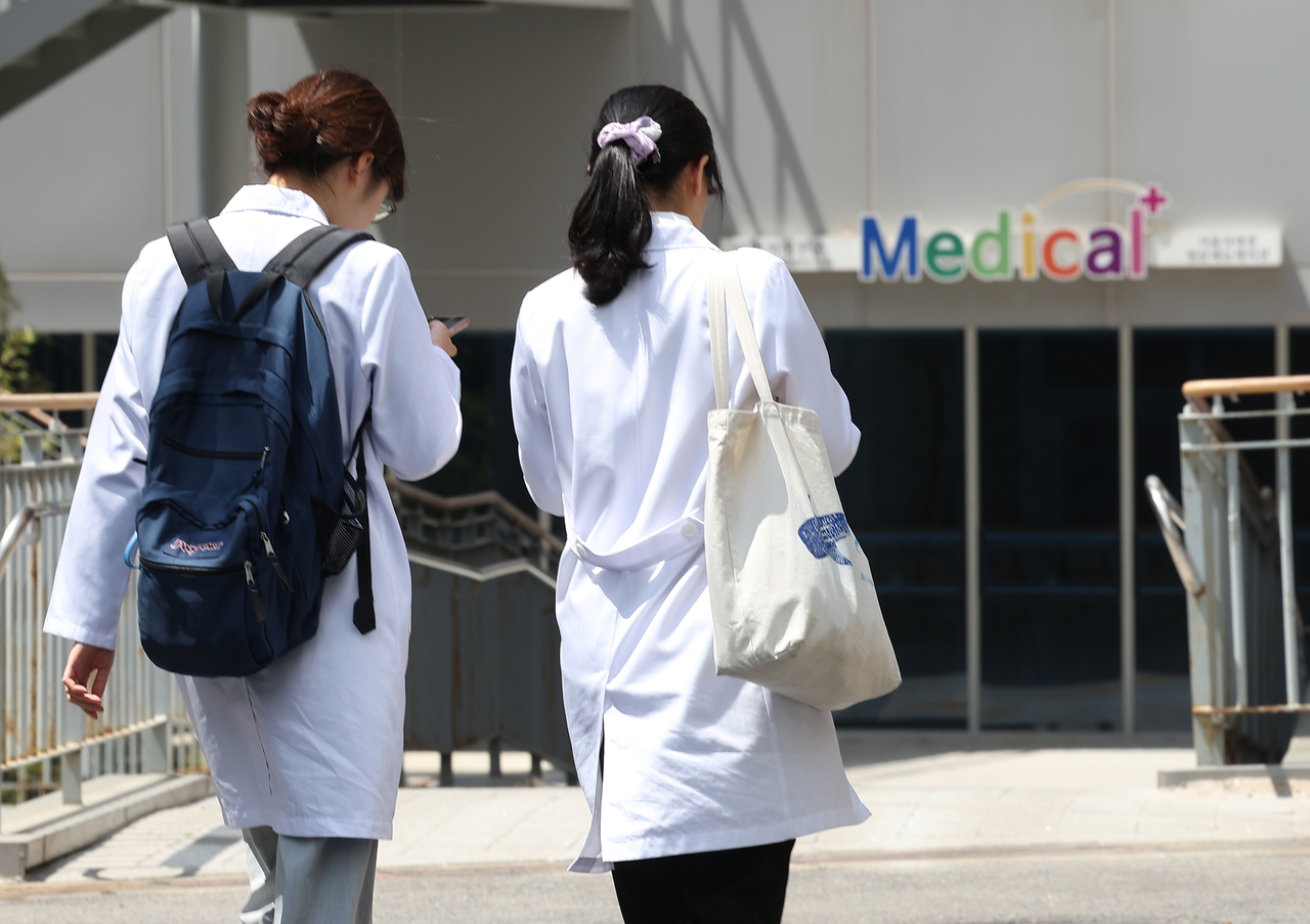 Students in gowns walk at a medical school in Seoul on May 9. (Yonhap)