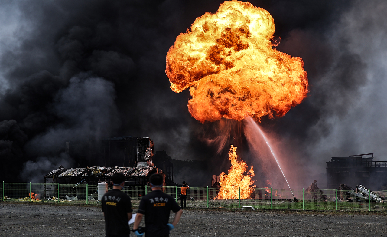 Officials from the Korea Crime Scene Investigation monitor firefighting efforts at a cosmetic material factory in Yeongcheon, North Gyeongsang Province, on Sunday. (Yonhap)